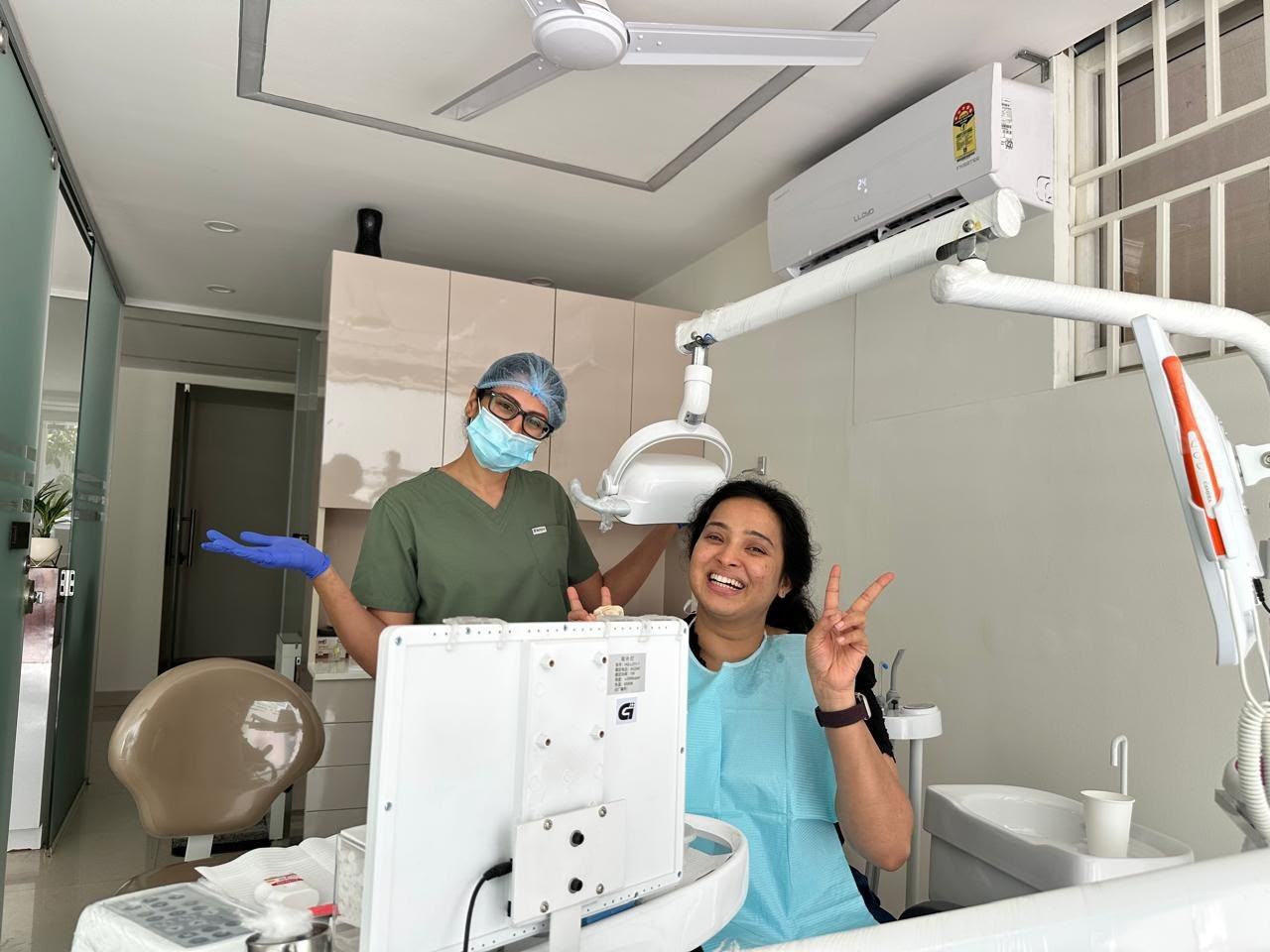 A patient smiling in the chair at the end of her appointment at Tooth District, Koramangala